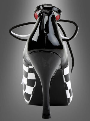 Harlekin Schachbrett Schuhe Clown – schwarze Schuhe mit hohen Absätzen und glänzender Oberfläche, mit schwarz-weißen Schachbrettmuster-Seiten und schwarzen Schnürsenkeln, von hinten vor einem grauen Farbverlaufshintergrund präsentiert; ein auffälliges Statement-Stück, inspiriert von klassischen Harlekin-Schuhen.