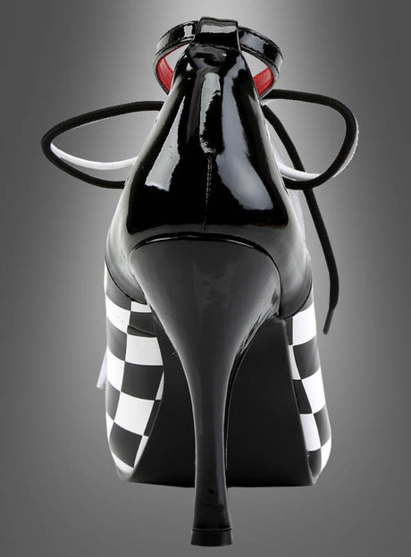 Harlekin Schachbrett Schuhe Clown – schwarze Schuhe mit hohen Absätzen und glänzender Oberfläche, mit schwarz-weißen Schachbrettmuster-Seiten und schwarzen Schnürsenkeln, von hinten vor einem grauen Farbverlaufshintergrund präsentiert; ein auffälliges Statement-Stück, inspiriert von klassischen Harlekin-Schuhen.