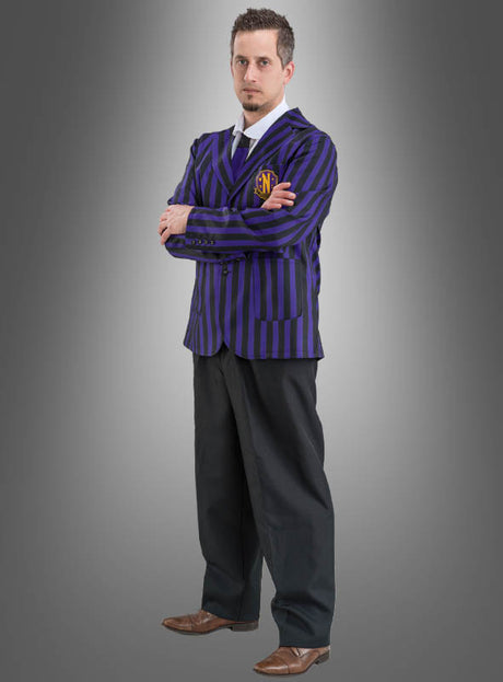 Ein Mann steht mit verschränkten Armen da. Er trägt die „Wednesday Herren Schuluniform Schwarz Lila“ – einen blau-schwarz gestreiften Blazer, der von der Nevermore Academy inspiriert ist, dazu eine schwarze Hose, braune Schuhe und eine Krawatte – vor einem grauen Hintergrund mit Farbverlauf.