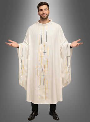 Ein Mann steht mit ausgebreiteten Armen da und trägt ein cremefarbenes Priester-Messgewand mit Kreuzen, das auf der Vorderseite und an den Ärmeln vertikale Kreuzmuster in Gelb und Blau aufweist, die sich von einem grauen Hintergrund mit Farbverlauf abheben.