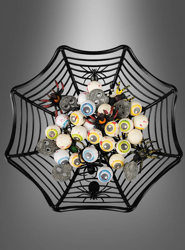 Draufsicht auf die „Spinnennetz“-Dekoschale Halloween (27 cm), gefüllt mit künstlichen Augäpfeln, Plastikspinnen und kleinen Totenkopf-Dekorationen auf grauem Hintergrund – die perfekte Halloween-Tischdekoration, um Halloween-Süßigkeiten im gruseligen Stil zu präsentieren.
