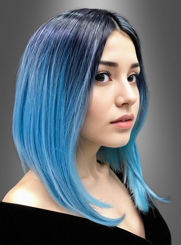 Eine Frau mit glattem, schulterlangem Haar, dessen Farbe vom schwarzen Ansatz zu leuchtendem Blau an den Spitzen übergeht, posiert vor einem grauen Hintergrund – perfekt, um die Zwei-Ton-Farbe-Perücke „Lilia“ in Szene zu setzen, eine glatte Langhaarperücke mit zweifarbigem Farbverlauf, die sich ideal als stilvolle Karnevalsperücke eignet.