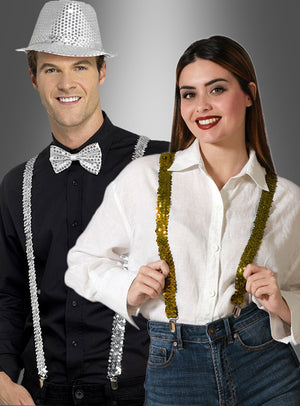 Ein Mann mit einem silbernen Paillettenhut, einer Fliege und silbernen Pailletten-Hosenträgern steht neben einer Frau in einem weißen Hemd und goldenen Pailletten-Hosenträgern; beide präsentieren ihre glitzernden Accessoires – goldene oder silberne Pailletten-Hosenträger – vor einem grauen Hintergrund mit Farbverlauf.