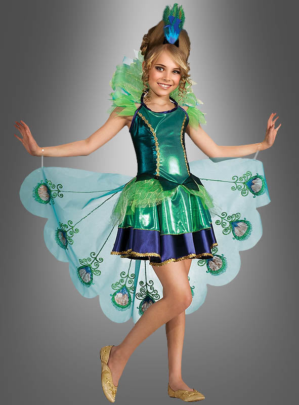 Ein Mädchen in einem leuchtend grün-blauen „Wunderschöner Pfau“-Mädchenkostüm mit Federverzierungen, goldenen Schuhen und einem Pfauenkopfschmuck, das vor einem grauen Hintergrund mit Farbverlauf steht – eine umwerfende Wahl unter den Tierkostümen für Kinder.