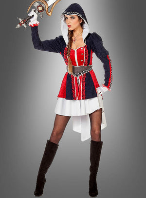 Eine Frau, die das „Fantasy Kriegerin“-Damenkostüm trägt – ein mittelalterlich anmutendes Design in Rot, Schwarz und Weiß mit angesetzter Kapuze –, ist mit schwarzen Stiefeln, einem Gürtel und einem Zier-Schwert ausgestattet und posiert vor einem grauen Hintergrund.