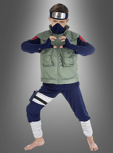 Ein Kind im „Kakashi Hatake Kinder-Cosplay-Naruto“-Kostüm, inspiriert von „Naruto Shippuden“, trägt ein Stirnband, eine Maske, eine grüne Weste, ein blaues Hemd und eine blaue Hose, während es ein Handzeichen macht und barfuß vor einem grauen Hintergrund mit Farbverlauf steht.