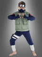 Ein Kind im „Kakashi Hatake Kinder-Cosplay-Naruto“-Kostüm, inspiriert von „Naruto Shippuden“, trägt ein Stirnband, eine Maske, eine grüne Weste, ein blaues Hemd und eine blaue Hose, während es ein Handzeichen macht und barfuß vor einem grauen Hintergrund mit Farbverlauf steht.
