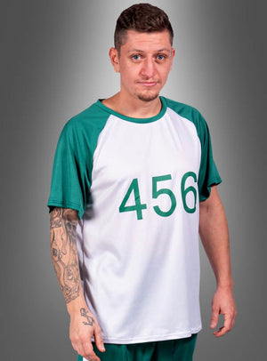 Eine Person mit kurzen Haaren und einem Spitzbart trägt das „T-Shirt Game Spieler Nummer 456 Herren“, das weiß und grün ist und auf der Vorderseite die Nummer 456 vor einem grauen Hintergrund zeigt.