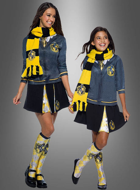 Zwei Mädchen in passenden, von Hufflepuff inspirierten Schuluniformen, jeweils mit dem „Hufflepuff-Schal gelb Harry Potter“ sowie gelben und schwarzen Strickjacken, karierten Röcken und kniehohen Socken. Sie stehen lächelnd vor einem grauen Hintergrund – perfekt für jeden Fan von Harry-Potter-Kostümen oder offiziellen Lizenzprodukten.