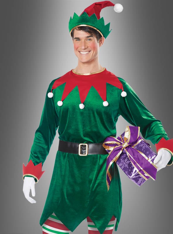 Eine Person, die das grüne Weihnachtself-Kostüm „Unisex Santas Helfer“ trägt und eine rote Mütze aufhat, hält vor einem grauen Hintergrund eine lila Geschenkbox in der Hand, die mit einem goldenen Band verziert ist.