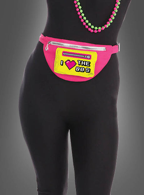 Eine Person, die ein schwarzes Outfit, die pinkfarbene 80er-Jahre-Gürteltasche mit der Aufschrift „I ♥ THE 80s“ sowie grüne und pinkfarbene Perlenketten trägt – perfekt für jede 80er-Jahre-Mottoparty.
