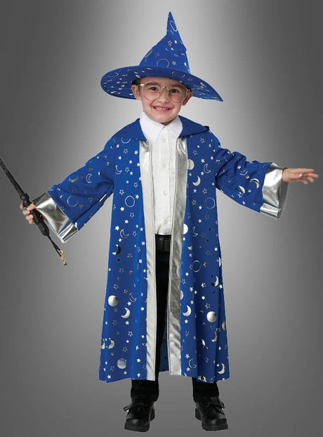 Ein Kind mit Brille trägt ein „Blauer Zauberer“-Kinderkostüm, das mit silbernen Sternen und Monden verziert ist, hält einen Zauberstab in der Hand und steht vor einem neutralen grauen Hintergrund.