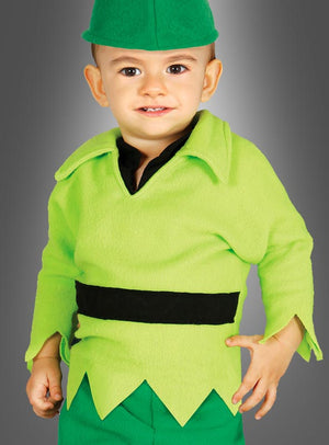 Ein Kleinkind mit einer grünen Mütze und einem leuchtend grünen Outfit mit schwarzem Gürtel steht lächelnd vor einem grauen Hintergrund – ein entzückendes „Kleiner Peter“-Märchenkostüm für Jungen, perfekt für jeden märchenhaften Anlass.