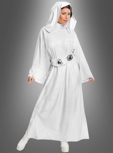 Eine Person, die das Original-Prinzessin-Leia-Kostüm aus „Star Wars“ trägt – bestehend aus einem langen weißen Gewand mit Kapuze und einem breiten Gürtel –, posiert vor einem grauen Hintergrund mit Farbverlauf.