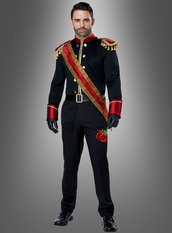 Ein Mann im Kostüm des „Dunkler Märchenprinz“ – ein schwarz-rotes, militärisch anmutendes Kostüm mit goldenen Verzierungen, schwarzen Handschuhen und einer roten Schärpe – steht vor einem schlichten grauen Hintergrund.