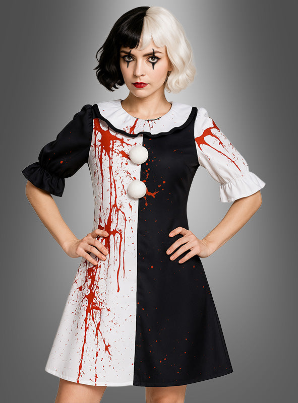 Eine Frau in einem „Blutiges Horrorclown“-Kleid – einem schwarz-weißen, geteilten Kleid mit roten Farbspritzern, weißen Knöpfen und Clown-inspiriertem Make-up –, die mit den Händen in den Hüften vor einem grauen Hintergrund steht. Perfekt für alle, die ein gruseliges oder einzigartiges Halloween-Kostüm suchen.