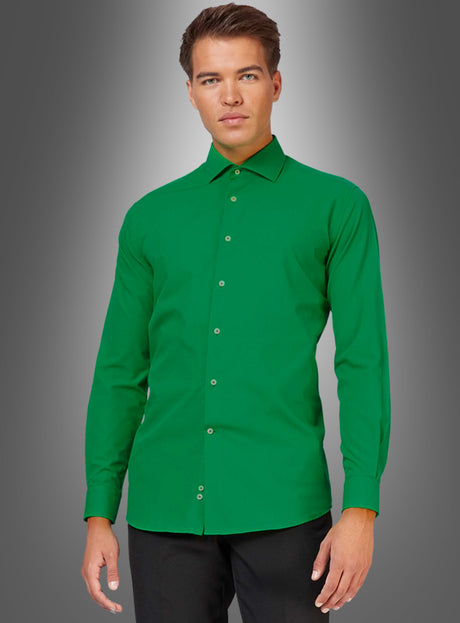 Ein Mann steht vor einem grauen Hintergrund mit Farbverlauf, blickt mit neutralem Gesichtsausdruck geradeaus und trägt das „Grüne Langarmhemd für Herren“ mit figurbetontem Schnitt sowie eine schwarze Hose. Das Hemd ist leicht zu bügeln und bietet sowohl Stil als auch Komfort für den Alltag.