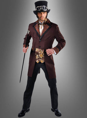 Eine Person im Steampunk-Gentleman-Kostüm – bestehend aus Zylinder, Schutzbrille, Spazierstock, braunem Mantel, gemusterter Weste, gestreifter Hose und Anzugschuhen, die die klassische viktorianische Herrenmode verkörpern – steht vor einem grauen Hintergrund mit Farbverlauf.
