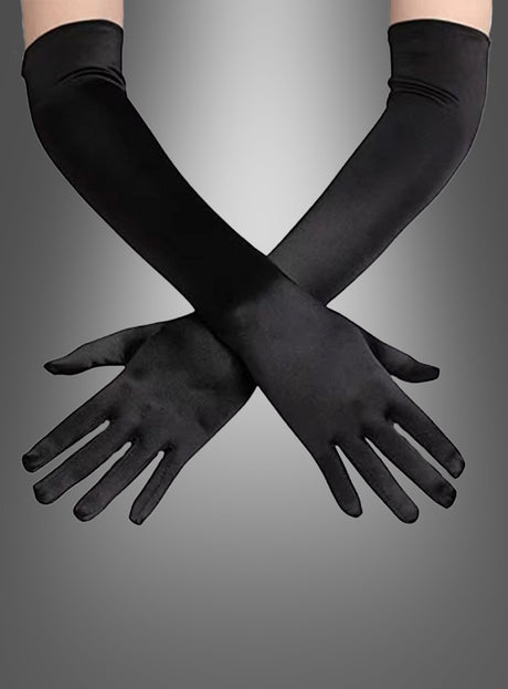 Ein Paar schwarze Satin-Handschuhe (lang, verschiedene Farben) wird an gekreuzten Armen vor einem grau verlaufenden Hintergrund getragen.