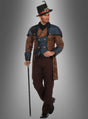 Ein Mann im Steampunk-Anzug „Sir Philbert Blue“ – einem viktorianisch inspirierten Outfit mit Zylinder, braun gemustertem Mantel, blauer Weste und Spazierstock – steht vor einem grauen Hintergrund.