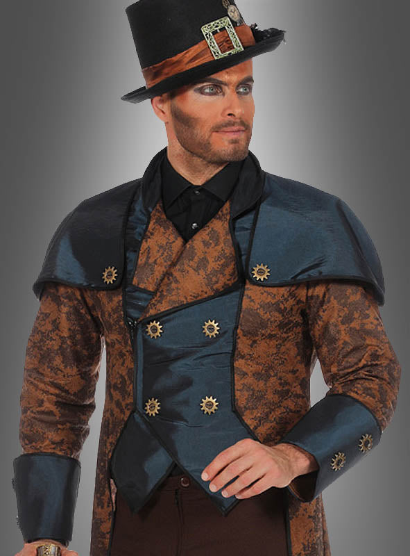 Vor einem grauen Hintergrund steht ein Mann, der den mit Zahnrädern verzierten Steampunk-Anzug „Sir Philbert Blue“ trägt, dazu einen schwarzen Zylinder mit Schutzbrille und ein auffälliges Make-up.