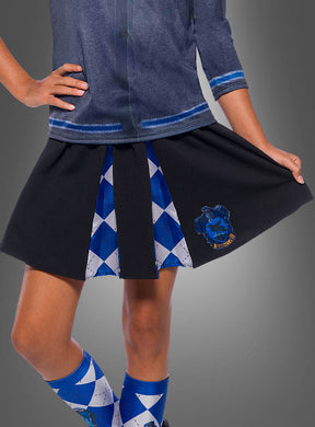 Eine Person, die einen blau-schwarzen, plissierten „Kinder Ravenclaw Rock Harry Potter“-Rock mit einem von Ravenclaw inspirierten Wappen, blaue Argyle-Kniestrümpfe und ein blaues Oberteil trägt und mit einer Hand in der Hüfte steht – perfekt für jeden jungen Fan, der auf der Suche nach einer authentischen Harry-Potter-Schuluniform oder einem Kostüm für Mädchen ist.