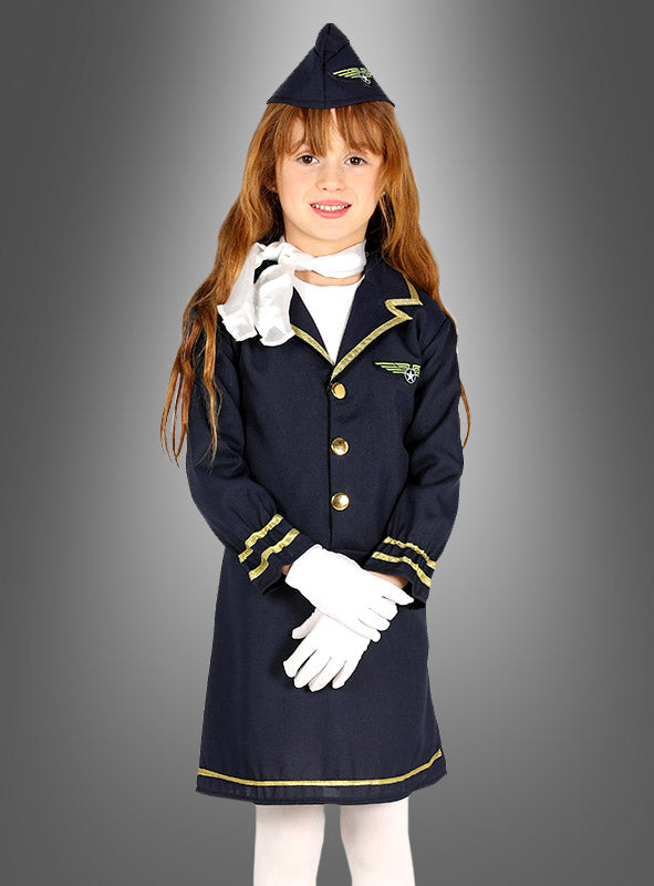 Ein junges Mädchen im Stewardess-Kinderkostüm – bestehend aus einer marineblauen Pilotenuniform mit passender Mütze, weißen Handschuhen und einem Schal – steht vor einem grauen Hintergrund mit Farbverlauf und eignet sich somit ideal als Karnevalskostüm für Mädchen oder als Kinderkostüm für Mottopartys und Verkleidungsveranstaltungen.