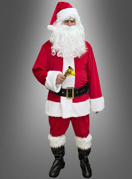 Eine Person, die das „Weihnachtsmann-Kostüm rot, 6-teilig“ trägt, hält eine goldene Glocke in der Hand und steht vor einem schlichten grauen Hintergrund.