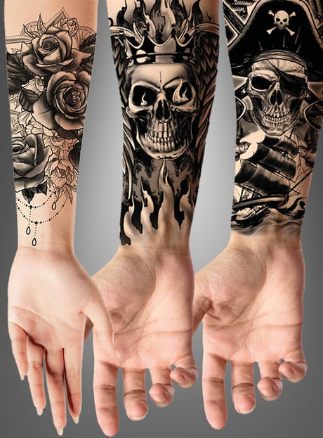 Drei Unterarme mit Tätowierungen in verschiedenen Designs: eines mit Rosen und Perlen, eines mit einem gruseligen Motiv aus einem Totenkopf und Flammen und eines mit einer Tätowierung am Unterarm, die einen Piratentotenkopf, ein Schiff und gekreuzte Knochen zeigt.