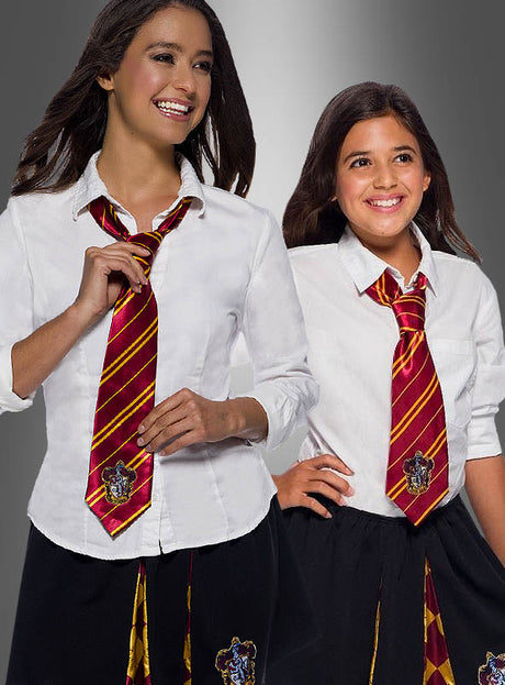 Zwei Mädchen in weißen Hemden, schwarzen Röcken mit Gryffindor-Wappen und der Gryffindor-Krawatte mit Wappen stehen vor einem grauen Hintergrund mit Farbverlauf und verkörpern damit perfekt den klassischen Look einer Hogwarts-Schuluniform, die vom Harry-Potter-Kostüm inspiriert ist.