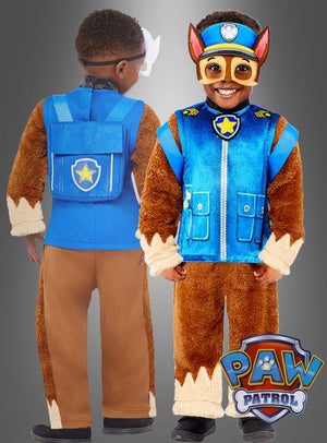 Ein Kind präsentiert das „Deluxe Chase Paw Patrol“-Kostüm von vorne und von hinten. Es besteht aus einer braunen Hose, einer blauen Weste mit Abzeichen und Kunstfell-Details sowie einer Charaktermaske. Dieses liebevoll gestaltete Kinderkostüm verwandelt jeden kleinen Fan in den mutigen Polizeihund Chase. Das PAW Patrol-Logo ist deutlich zu sehen.