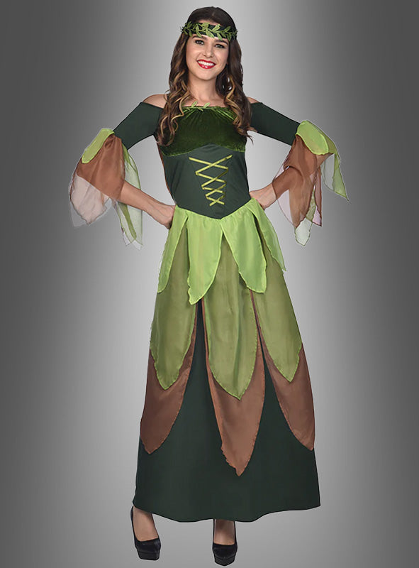 Vor einem grauen Hintergrund mit Farbverlauf steht eine Frau und lächelt. Sie trägt ein „Grüne Waldfee“-Damenkostüm – ein langes, grün-braunes Kleid mit Blattmotiv, transparenten Ärmeln und einem grünen Stirnband.