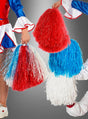 Drei Cheerleaderinnen, gekleidet in einheitliche Kostüme mit ausgestelltem Ärmeln, posieren vor einem neutralen Hintergrund und halten dabei Cheerleader-Pompons in leuchtendem Rot, Weiß und Blau in den Händen.