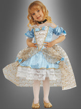 Ein kleines Kind trägt das „Prinzessin“-Kinderkostüm – ein blau-goldenes Kleid mit Spitzendetails –, dazu weiße Strumpfhosen und goldene Schuhe, und steht lächelnd vor einem grauen Hintergrund.