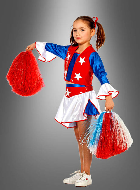 Ein junges Mädchen in einem rot-weiß-blauen Cheerleader-Outfit hält rot-weiße Cheerleader-Pompons in der Hand und steht vor einem grauen Hintergrund mit Farbverlauf.