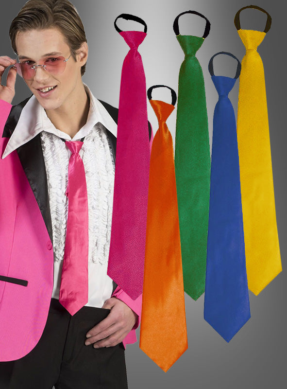 Eine Person in einem rosa Anzug mit einer weißen Rüschenbluse und einer rosa Krawatte steht neben fünf Krawatten in verschiedenen Farben – rosa, orange, grün, blau und gelb – vor einem grauen Hintergrund: eine farbenfrohe Präsentation moderner Herrenaccessoires.