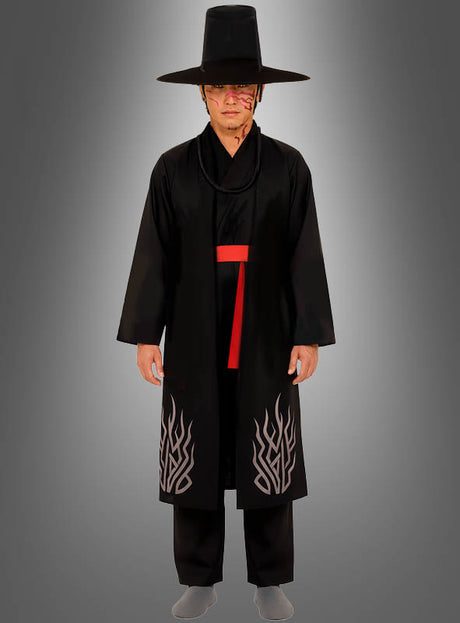 Eine Person, die das K-Pop-Kostüm „Black Demon“ für Herren trägt – bestehend aus einem traditionellen koreanischen Hut, einer langen schwarzen Robe mit Flammenmustern, einer roten Schärpe und Gesichtsbemalung –, steht vor einem schlichten grauen Hintergrund und sorgt so für einen auffälligen Look, der sich ideal für Cosplay oder thematische Karnevalsveranstaltungen eignet.