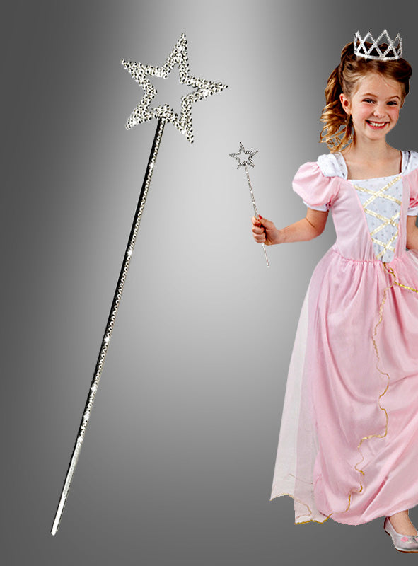 Ein junges Mädchen in einem rosa Prinzessinnenkleid und mit einer Tiara hält den schimmernden Zauberstab „Estelle Stern“ in der Hand – ein bezauberndes Accessoire, das sich perfekt als Kostümzubehör für jedes Märchenabenteuer eignet. Links ist eine Nahaufnahme des Zauberstabs vor einem grauen Hintergrund mit Farbverlauf zu sehen.