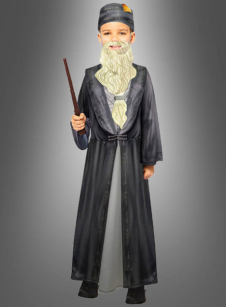 Ein Kind im Dumbledore-Kinderkostüm aus „Harry Potter“, mit langem weißem Bart, grauer Zaubererrobe, passendem Hut und einem Zauberstab in der Hand, das vor einem grauen Hintergrund steht.