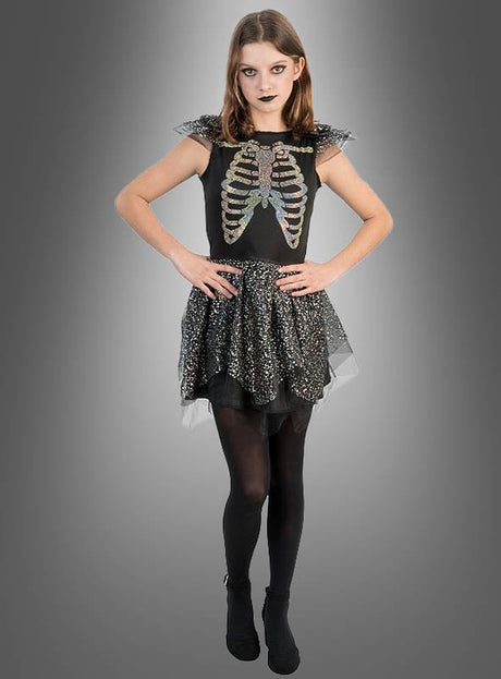 Vor einem grauen Hintergrund steht eine Person, die das „Schillerndes Skelett Kleid Mädchen“ mit seinem auffälligen Skelett-Print trägt, kombiniert mit schwarzen Strumpfhosen und dunklem Make-up – die perfekte Inspiration für alle, die auf der Suche nach einem auffälligen Halloween-Kostüm für Mädchen sind.