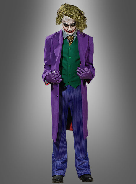 In dem Joker-Super-Deluxe-Kostüm „The Dark Knight“ – bestehend aus einem violetten Mantel, einer grünen Weste, einer gestreiften Hose, weißem Gesichts-Make-up, roten Lippen und dunklem Augen-Make-up – verkörpert dieses Filmkostüm für Herren vor einem grauen Hintergrund mit Farbverlauf perfekt den berüchtigten Bösewicht.