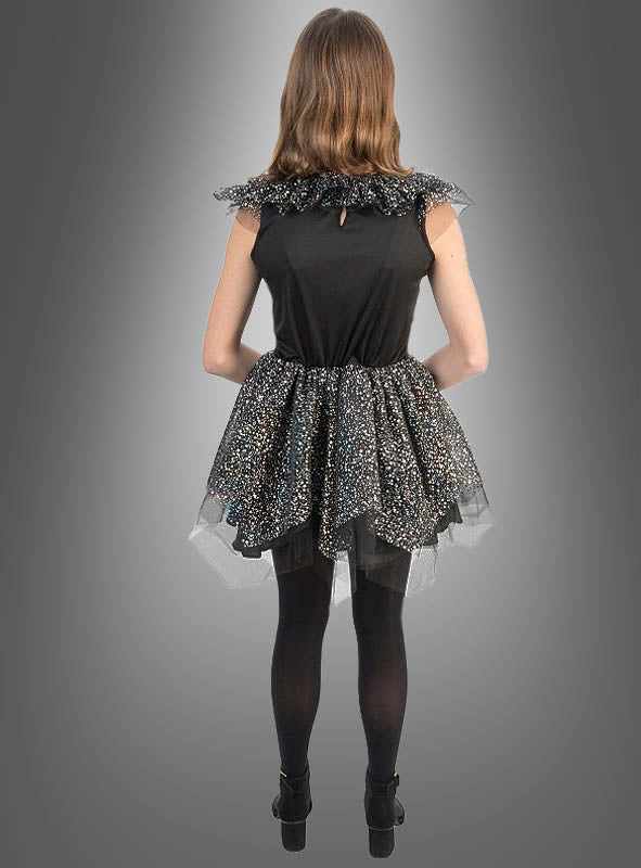 Eine Person steht mit dem Rücken zur Kamera und trägt ein schwarzes, ärmelloses „Schillerndes Skelett Kleid Mädchen“ mit einem mehrlagigen, glitzernden Rock, kombiniert mit schwarzen Strumpfhosen und Schuhen vor einem grauen Hintergrund mit Farbverlauf. Dieser Halloween-Kostüm-Look für Mädchen ist sowohl stilvoll als auch gruselig.