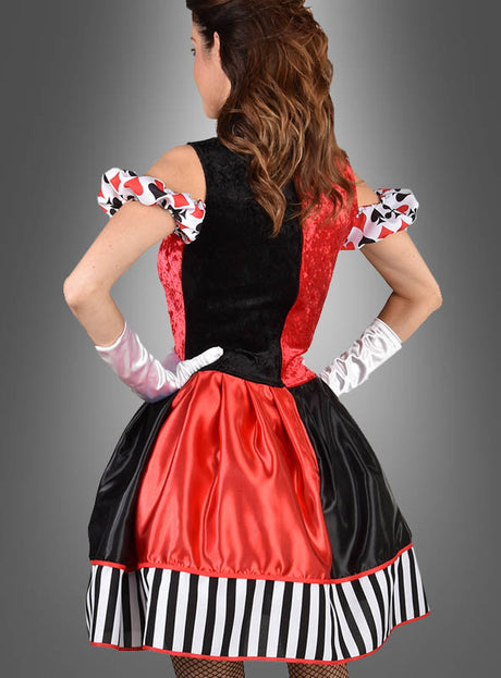 Eine Frau, die mit dem Rücken zur Kamera steht und das „Deluxe Kartenkönigin“-Kleid trägt – ein rot-schwarz-weißes Kostümkleid mit Puffärmeln, einem gestreiften Rock und weißen Handschuhen –, vor einem grauen Hintergrund.