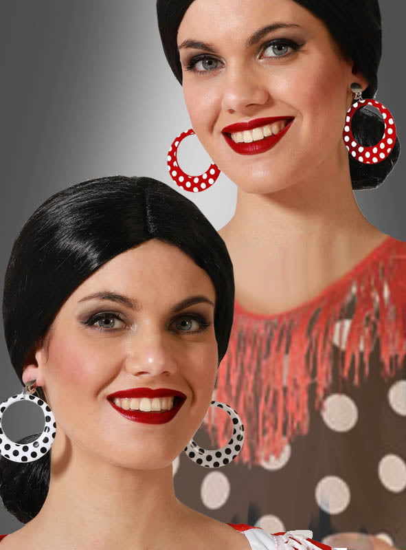Zwei Frauen mit dunklem Haar, rotem Lippenstift und gepunkteten Ohrringen im Stil der 50er Jahre lächeln in die Kamera. Die eine trägt ein rotes Oberteil mit Fransen, während die andere ihr braun-weiß gepunktetes Oberteil zu einem klassischen, von den 50er Jahren inspirierten Look kombiniert.