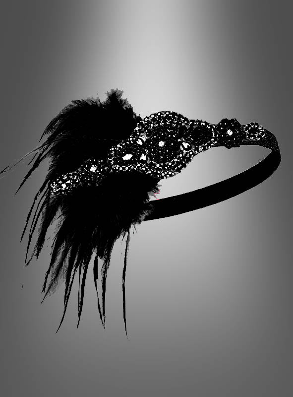 Ein schwarzes Haarband mit Pailletten, zartem Spitzenmuster und großen schwarzen Federakzenten – das an den legendären Kopfschmuck der 20er Jahre erinnert – wird vor einem grauen Hintergrund mit Farbverlauf präsentiert. Das elegante 20er-Jahre-Haarband „Lilli“ mit Strass und Perlen ist das perfekte Accessoire, um jedes Flapper-Kleid zu ergänzen oder als auffälliges 20er-Jahre-Haarband Vintage-Glamour zu verleihen.
