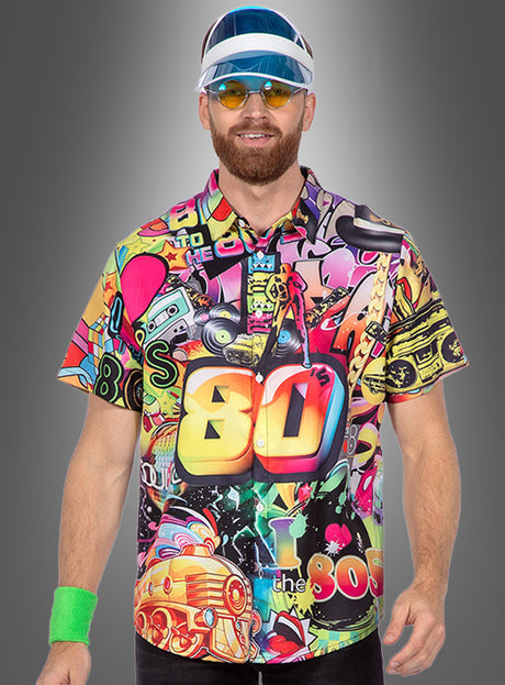 Ein Mann, der das „80er-Jahre-Outfit“-Hemd trägt – ein farbenfrohes Hemd mit auffälligem Aufdruck, das von den 1980er Jahren inspiriert ist –, dazu eine blau-weiße Schirmmütze, eine gelbe Sonnenbrille und ein grünes Armband, steht vor einem grauen Hintergrund mit Farbverlauf.