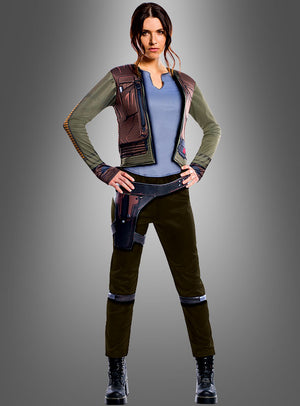 Eine Frau steht mit den Händen in den Hüften da. Sie trägt ein von Science-Fiction inspiriertes Outfit, das dem „Star Wars: Rogue One“-Kostüm von Jyn Erso für Erwachsene nachempfunden ist und aus einer eleganten Jacke, einem Funktionsgürtel und schwarzen Stiefeln besteht – wodurch der authentische Look dieses offiziellen „Star Wars“-Kostüms perfekt zur Geltung kommt –, vor einem schlichten Hintergrund mit Farbverlauf.