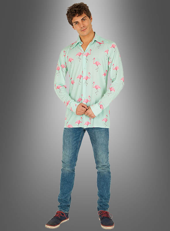Vor einem grauen Hintergrund mit Farbverlauf steht ein junger Mann, der das „Sommerparty Flamingo“-Hemd in Hellgrün mit verspielten rosa Flamingo-Motiven trägt, kombiniert mit blauen Jeans und schwarzen Schnürschuhen – damit ist es die perfekte Wahl für eine ausgelassene Strandparty oder als auffälliges Karnevalshemd.