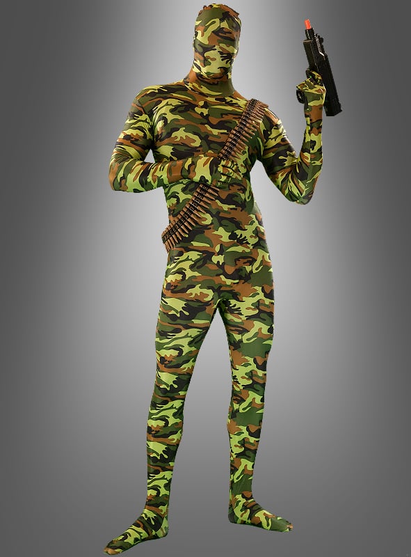 Eine Person, die einen militärischen Morphsuit-Tarnanzug trägt, eine Spielzeugpistole in der Hand hält und einen Patronengürtel trägt, steht vor einem grauen Hintergrund mit Farbverlauf.