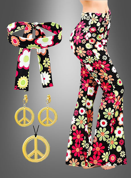 Eine Frau trägt die Schlaghose „Night Flower“ mit Accessoires, die sich durch ein fröhliches Blumenmuster und ein passendes Stirnband auszeichnet, während seitlich goldene Peace-Zeichen-Ohrringe und eine Halskette zu sehen sind.